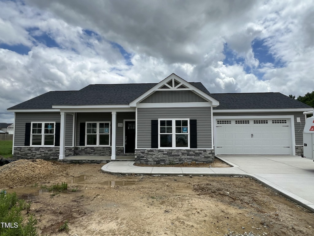 104 Waterstone Ct, Fremont, NC 27830 - craftsman-style home with stone siding, a garage, concrete driveway, and covered porch