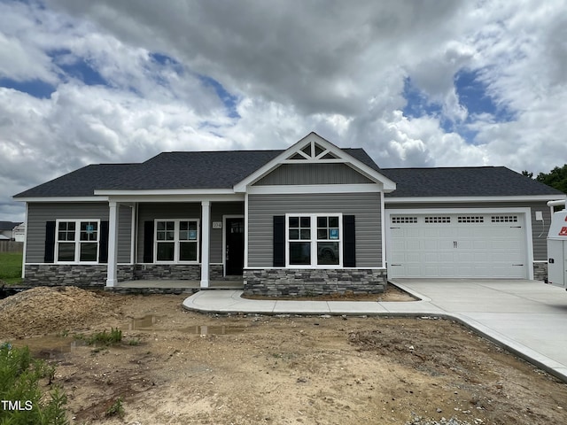 104 Waterstone Ct, Fremont, NC 27830 - craftsman-style home with stone siding, a garage, concrete driveway, and covered porch