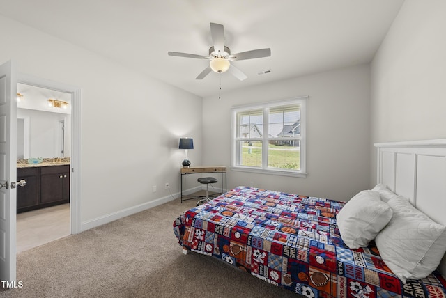 bedroom with ceiling fan, ensuite bath, visible vents, light carpet, and baseboards