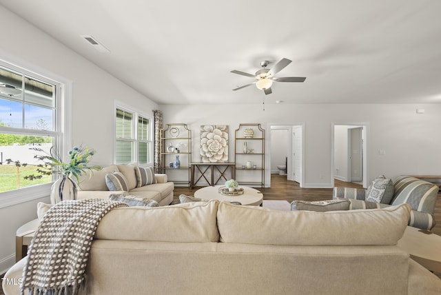 living room featuring baseboards, visible vents, wood finished floors, and ceiling fan