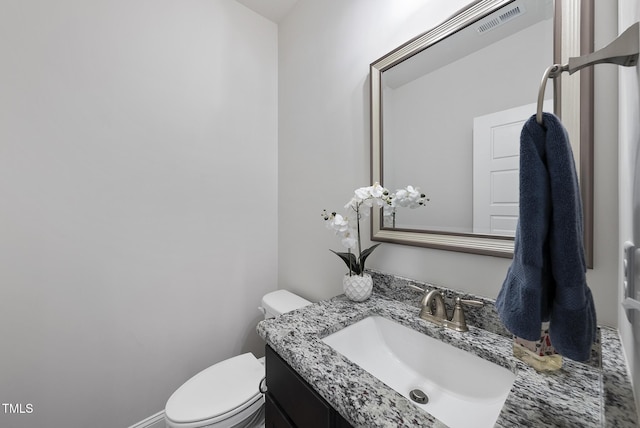 bathroom featuring visible vents, toilet, and vanity