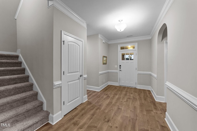 80 Bramble Ln, Clayton, NC 27527 - entryway with wood finished floors, stairway, baseboards, ornamental molding, and arched walkways