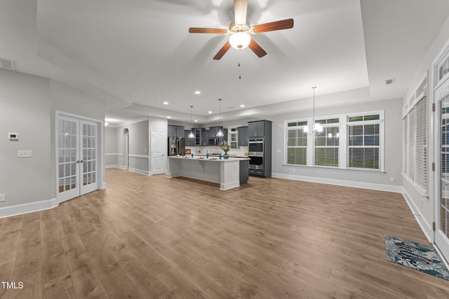 80 Bramble Ln, Clayton, NC 27527 - unfurnished living room featuring french doors, wood finished floors, a tray ceiling, baseboards, and recessed lighting