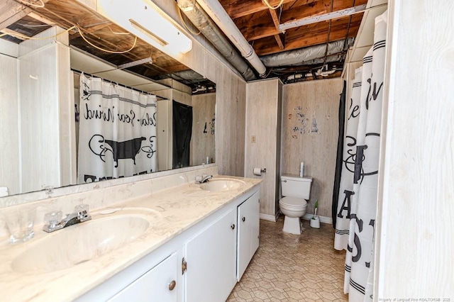 full bathroom featuring double vanity, toilet, and a sink