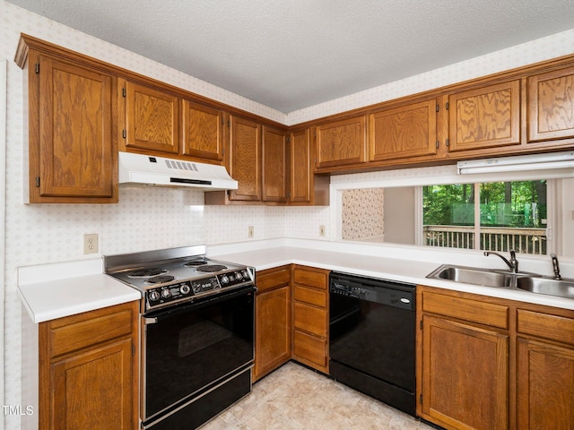 5148 Wallingford Dr, Raleigh, NC 27616 - kitchen featuring black appliances, under cabinet range hood, brown cabinetry, light countertops, and a textured ceiling