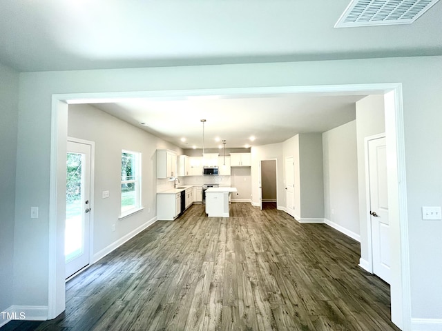 unfurnished living room with visible vents, baseboards, and dark wood-style floors