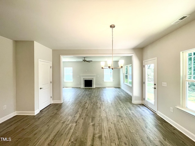 unfurnished living room with visible vents, baseboards, wood finished floors, and a fireplace with flush hearth