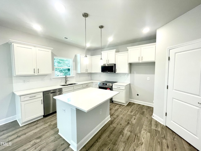 kitchen featuring white cabinets, visible vents, stainless steel appliances, light wood finished floors, and a sink