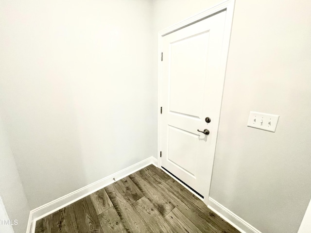 doorway to outside with dark wood-style floors and baseboards