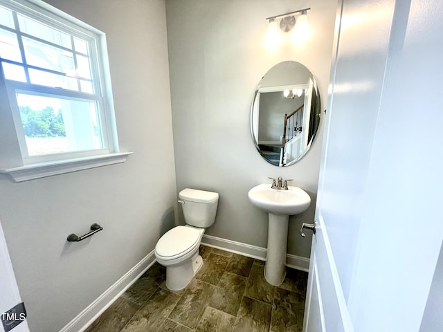 bathroom featuring toilet, a sink, and baseboards