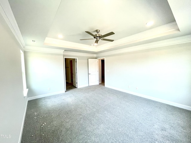 unfurnished bedroom with a raised ceiling, light colored carpet, baseboards, and ornamental molding