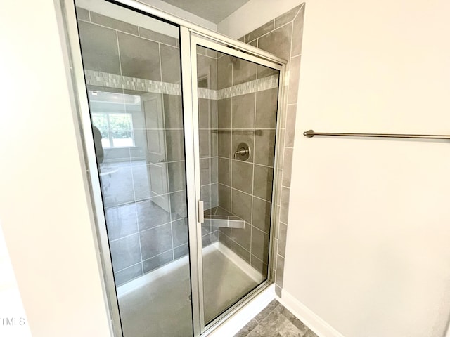 bathroom featuring a stall shower and baseboards