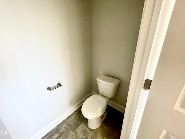 bathroom featuring toilet and baseboards