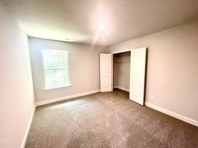 unfurnished bedroom with a closet, baseboards, and carpet floors