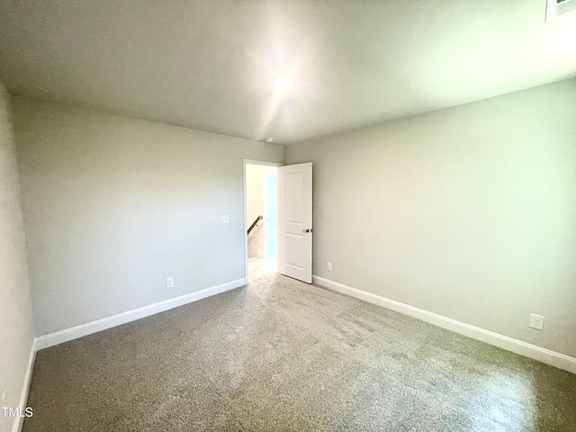 spare room featuring carpet flooring, baseboards, and visible vents