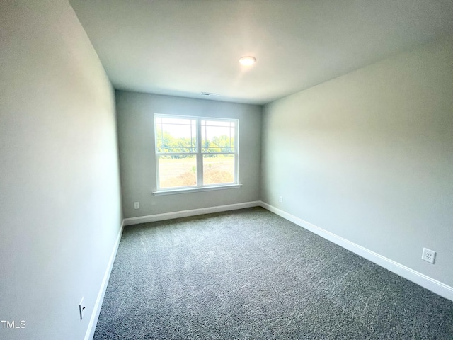 empty room featuring carpet flooring, visible vents, and baseboards