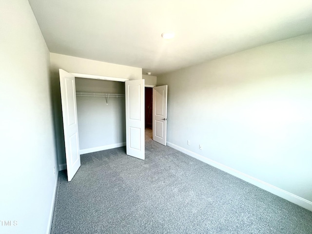 unfurnished bedroom featuring a closet, baseboards, and carpet floors