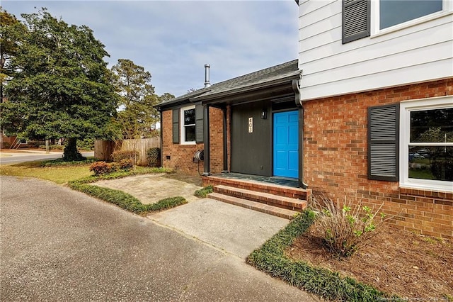 entrance to property with fence and brick siding
