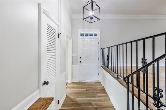 entryway with crown molding and wood finished floors
