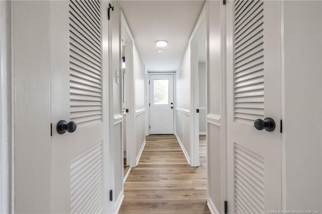 hall featuring baseboards and light wood-style floors