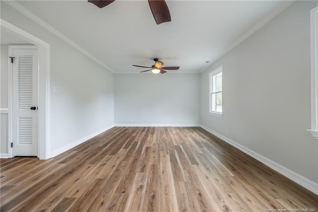 spare room featuring baseboards, ceiling fan, wood finished floors, and crown molding