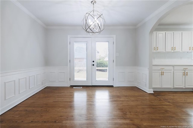 doorway with dark wood-style flooring, crown molding, arched walkways, french doors, and a notable chandelier