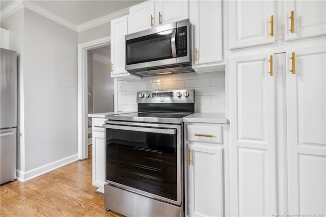 kitchen with light countertops, ornamental molding, backsplash, white cabinets, and appliances with stainless steel finishes