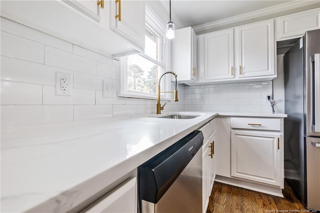 kitchen with a sink, backsplash, appliances with stainless steel finishes, white cabinets, and dark wood-style flooring