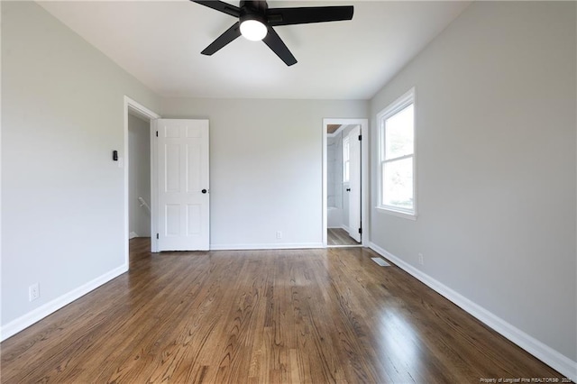 spare room featuring a ceiling fan, baseboards, and wood finished floors