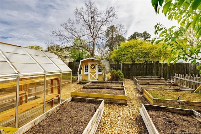 view of yard featuring a garden, an outbuilding, and a fenced backyard