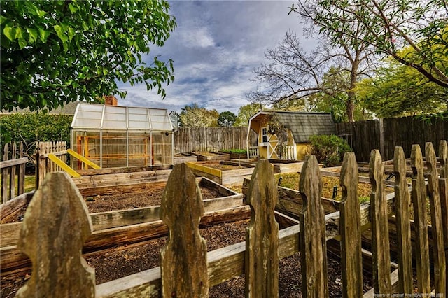 view of yard featuring a fenced backyard, an outdoor structure, an exterior structure, and a vegetable garden
