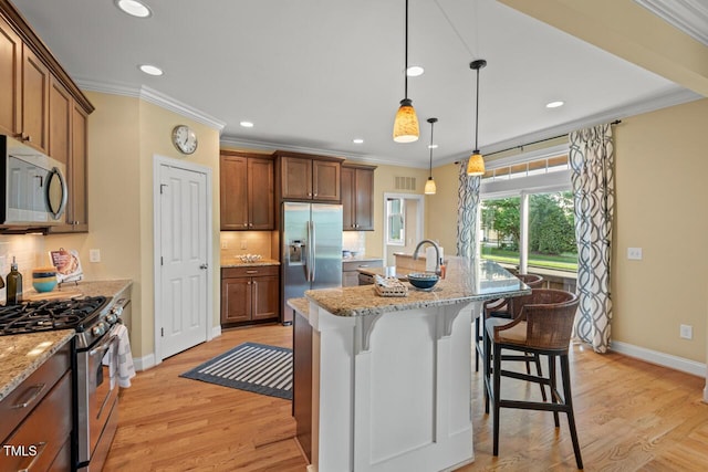 997 Windy Rd, Apex, NC 27502 - kitchen with appliances with stainless steel finishes, crown molding, backsplash, a kitchen breakfast bar, and light wood-style flooring