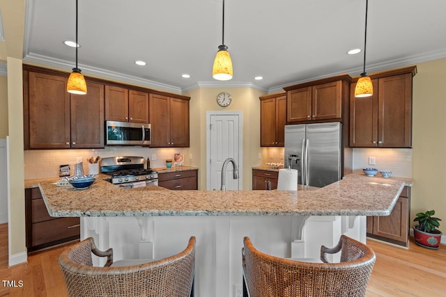 997 Windy Rd, Apex, NC 27502 - kitchen with appliances with stainless steel finishes, light wood-style floors, decorative backsplash, a kitchen breakfast bar, and ornamental molding