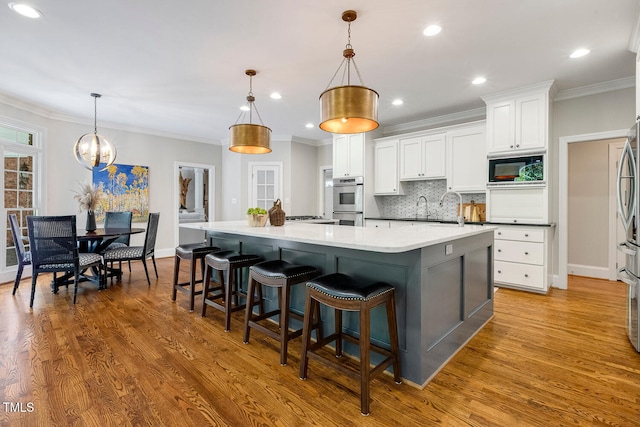 129 Trellingwood Dr, Morrisville, NC 27560 - kitchen with double oven, built in microwave, white cabinets, a large island, and crown molding
