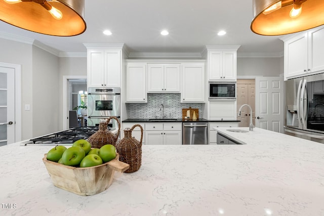 129 Trellingwood Dr, Morrisville, NC 27560 - kitchen with appliances with stainless steel finishes, a sink, crown molding, tasteful backsplash, and light stone counters