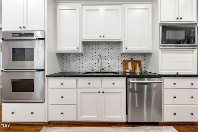 129 Trellingwood Dr, Morrisville, NC 27560 - kitchen with stainless steel appliances, a sink, white cabinetry, and dark stone counters