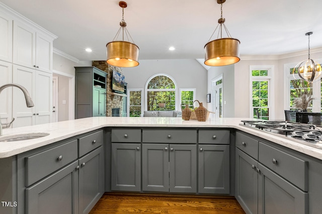129 Trellingwood Dr, Morrisville, NC 27560 - kitchen with gray cabinetry, a sink, stainless steel gas cooktop, light stone counters, and crown molding