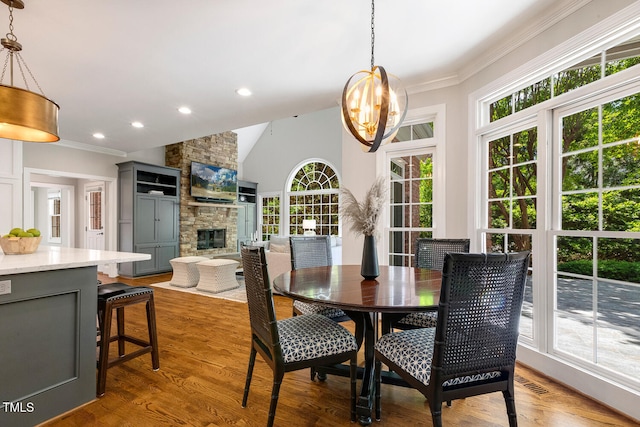 129 Trellingwood Dr, Morrisville, NC 27560 - dining room featuring plenty of natural light, a fireplace, crown molding, a chandelier, and wood finished floors