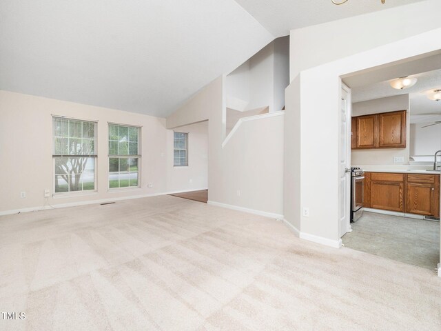5504 Cumberland Plain Dr, Raleigh, NC 27616 - unfurnished living room featuring light colored carpet, vaulted ceiling, a sink, and baseboards