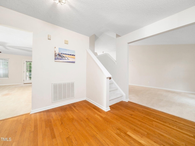 5504 Cumberland Plain Dr, Raleigh, NC 27616 - empty room with light wood-type flooring, baseboards, visible vents, and stairs