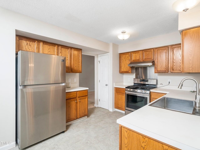 5504 Cumberland Plain Dr, Raleigh, NC 27616 - kitchen featuring under cabinet range hood, light floors, stainless steel appliances, a sink, and brown cabinetry