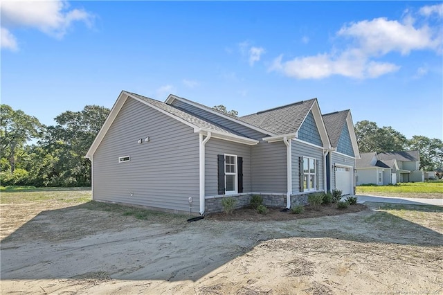 4915 High Branch Ct, Stedman, NC 28391 - view of side of property featuring an attached garage, stone siding, driveway, and roof with shingles