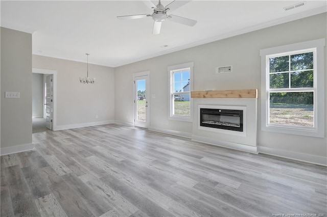 4915 High Branch Ct, Stedman, NC 28391 - unfurnished living room with a chandelier, a glass covered fireplace, healthy amount of natural light, and wood finished floors