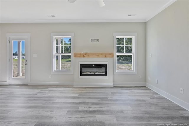 4915 High Branch Ct, Stedman, NC 28391 - unfurnished living room featuring ornamental molding, plenty of natural light, wood finished floors, and a glass covered fireplace
