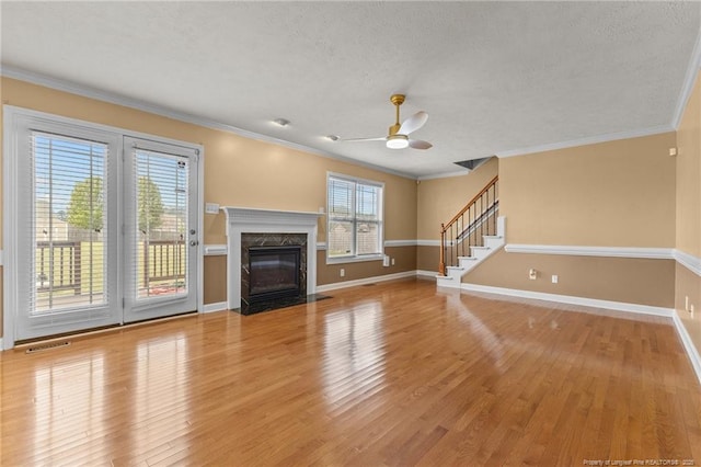 193 Wind Brook Ct, Raeford, NC 28376 - unfurnished living room featuring stairs, baseboards, light wood finished floors, visible vents, and a ceiling fan