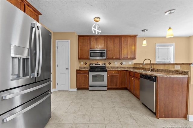 193 Wind Brook Ct, Raeford, NC 28376 - kitchen with hanging light fixtures, a sink, a peninsula, appliances with stainless steel finishes, and brown cabinets