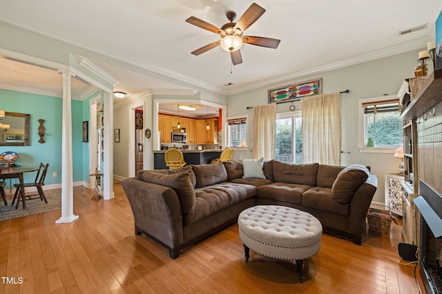 8437 Little Woody Ct, Zebulon, NC 27597 - living area featuring a ceiling fan, light wood-style flooring, ornamental molding, and visible vents