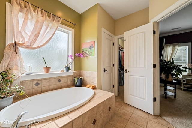 8437 Little Woody Ct, Zebulon, NC 27597 - full bathroom featuring tile patterned floors, visible vents, a spacious closet, and a garden tub