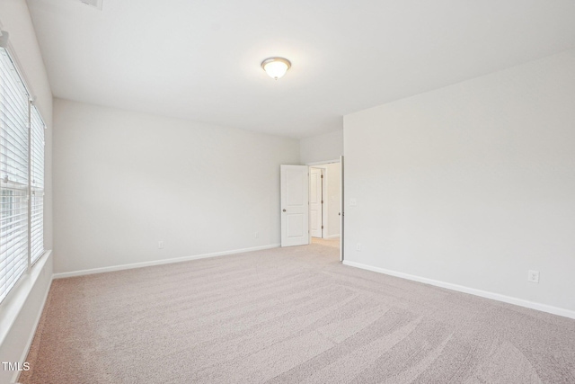 carpeted spare room featuring baseboards