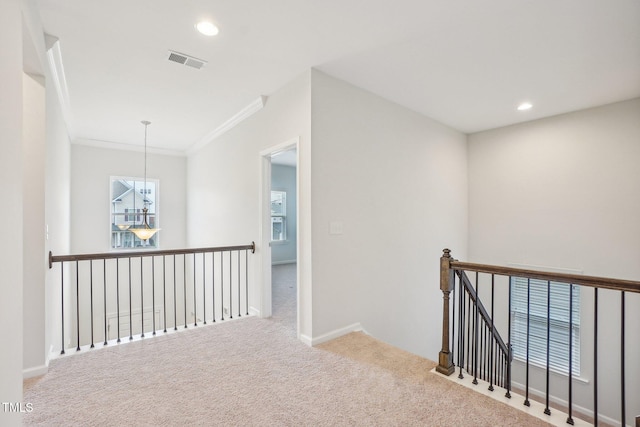 hallway with carpet flooring, an upstairs landing, visible vents, ornamental molding, and recessed lighting